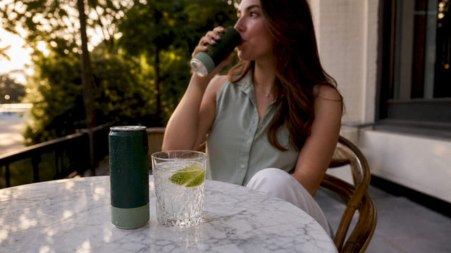 Chilled cannabis hard seltzer can with glass and woman drinking
