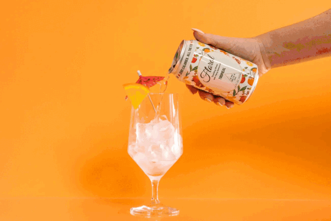 Chilled cans of Delta-9 THC seltzers surrounded by ice and fresh fruit, highlighting a refreshing, bubbly drink experience.
