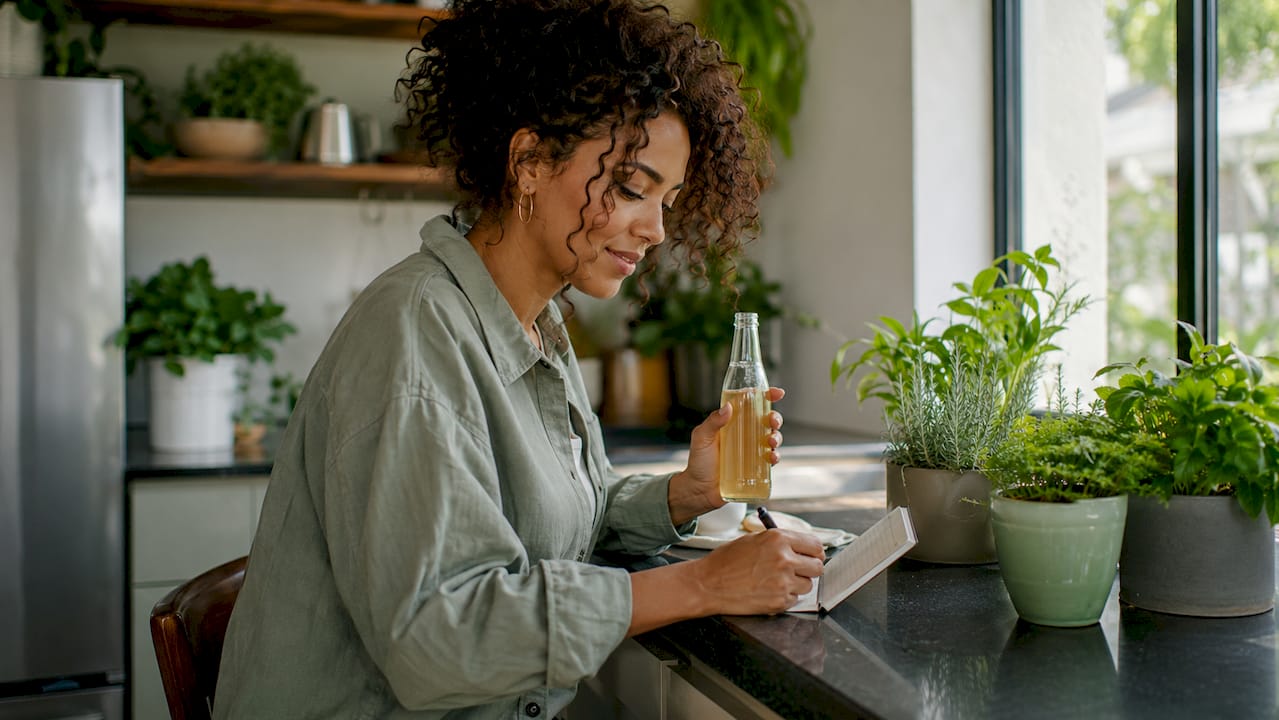 Woman sitting on couch with THC drink and notes