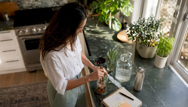 Woman preparing adaptogenic sparkling water at desk