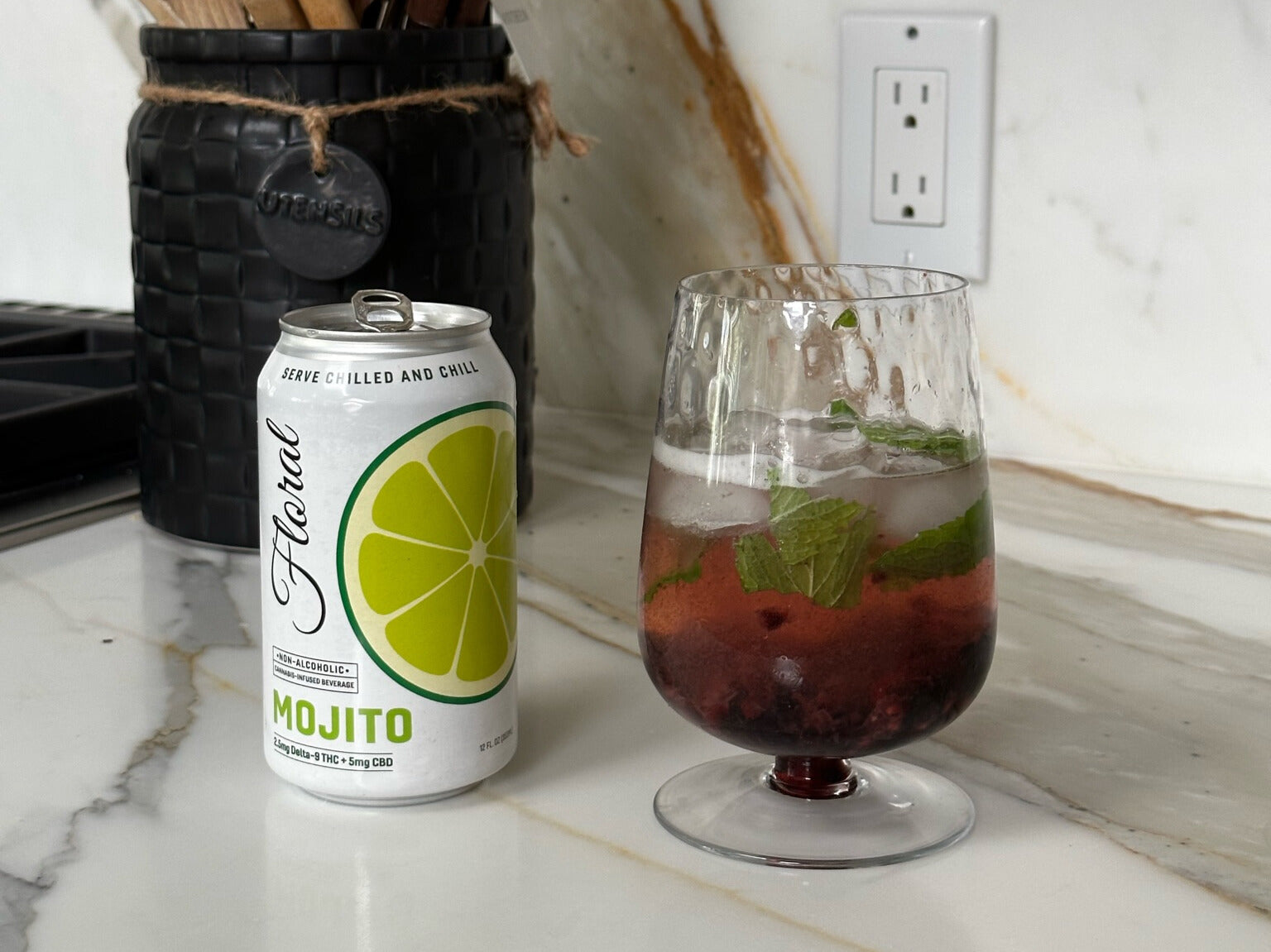 A can of Floral Beverages' Mojito flavor sitting beside a glass filled with the drink.