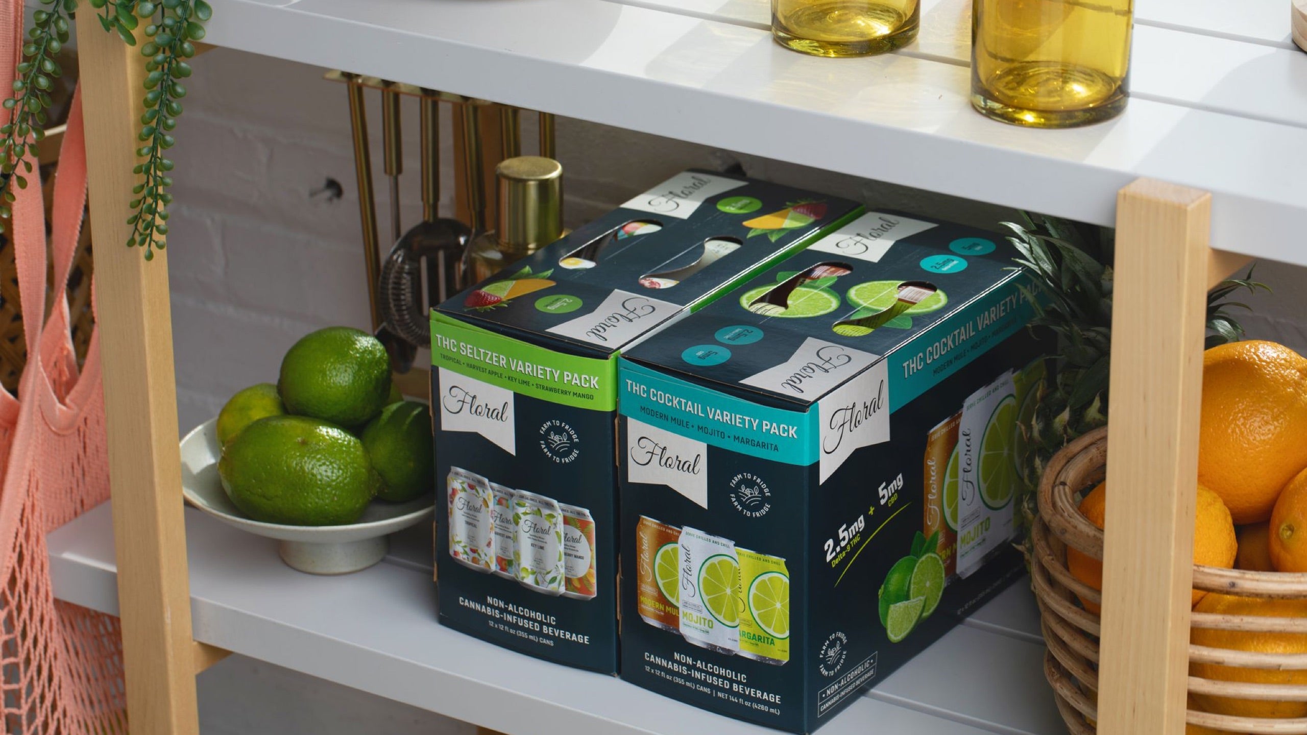 Floral THC beverage variety packs on a kitchen shelf with fresh fruit