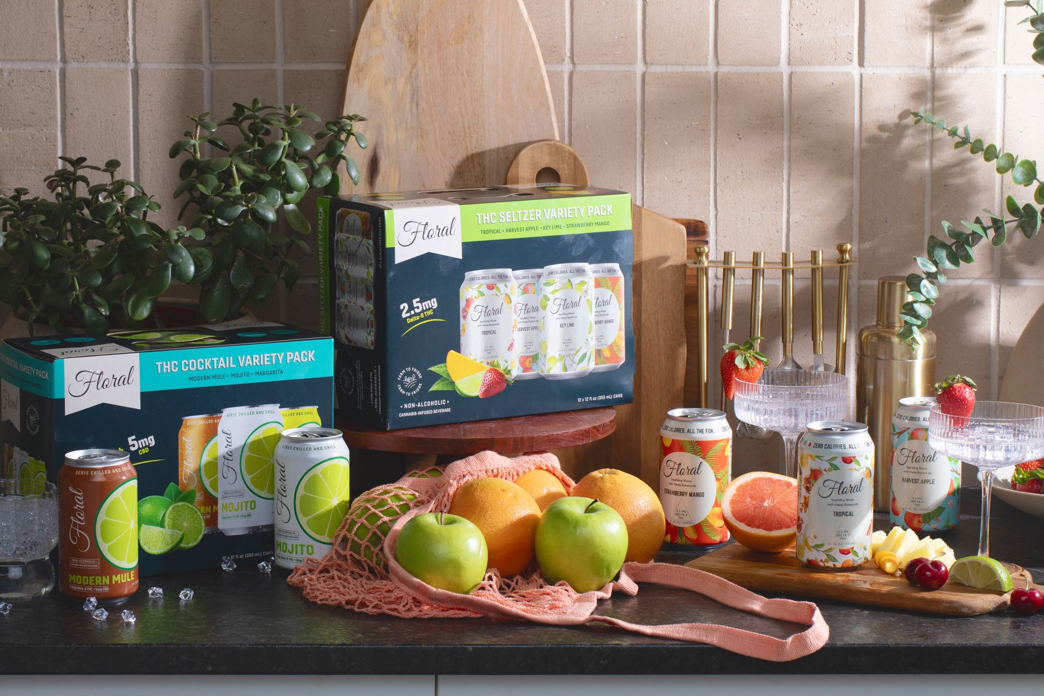 Floral THC beverage variety pack and cans on a kitchen counter with fresh fruit