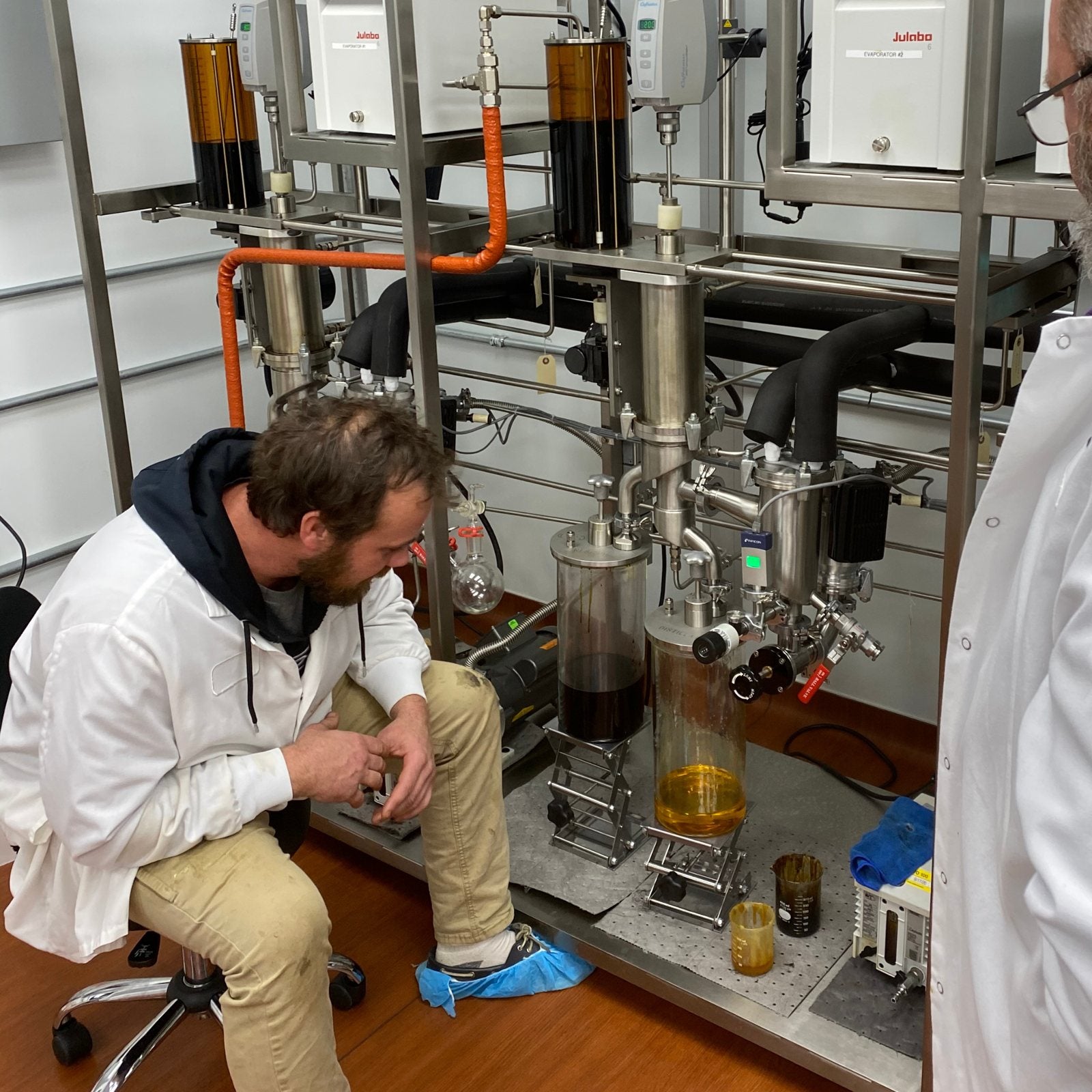 Technician operating distillation equipment