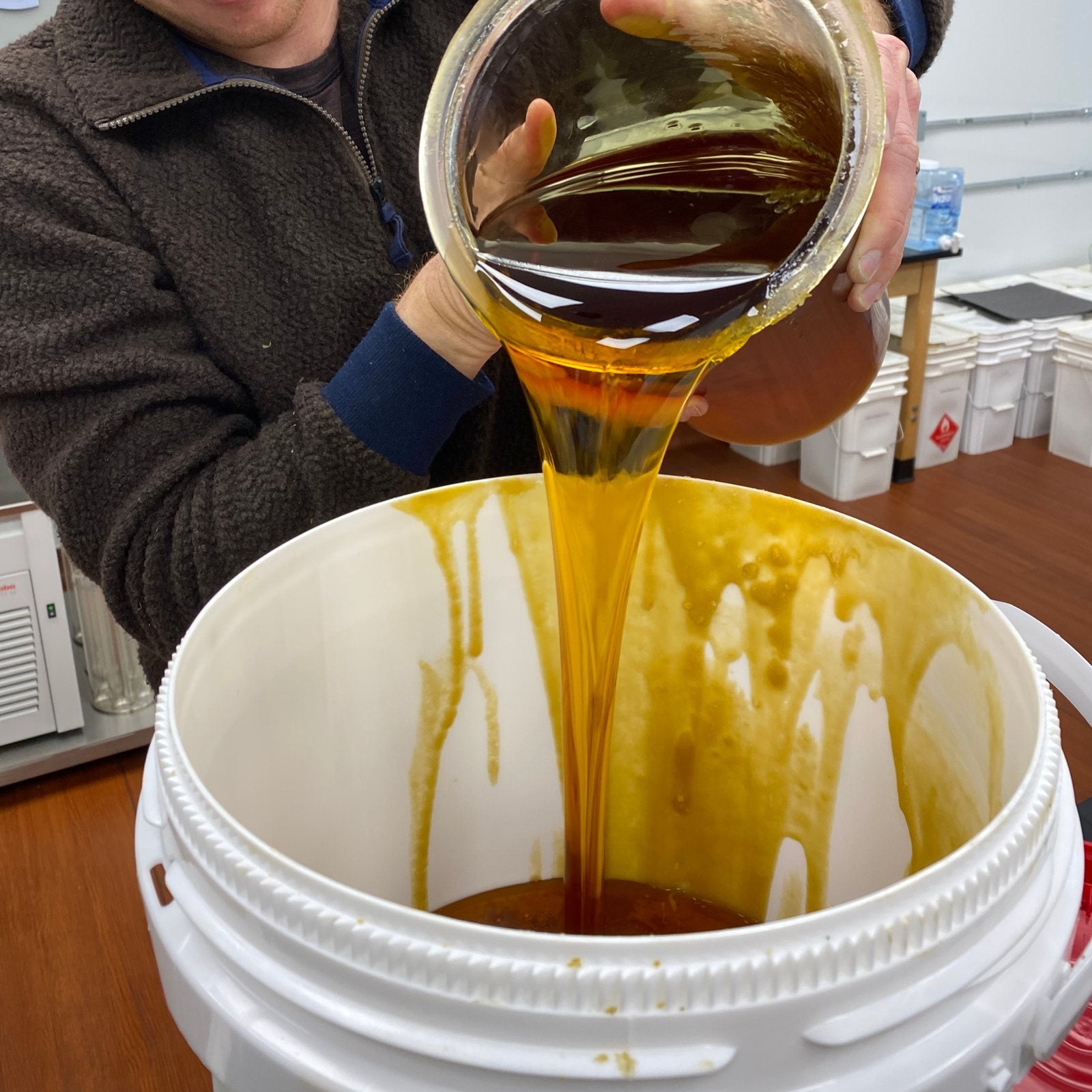 Golden hemp extract being poured into a container