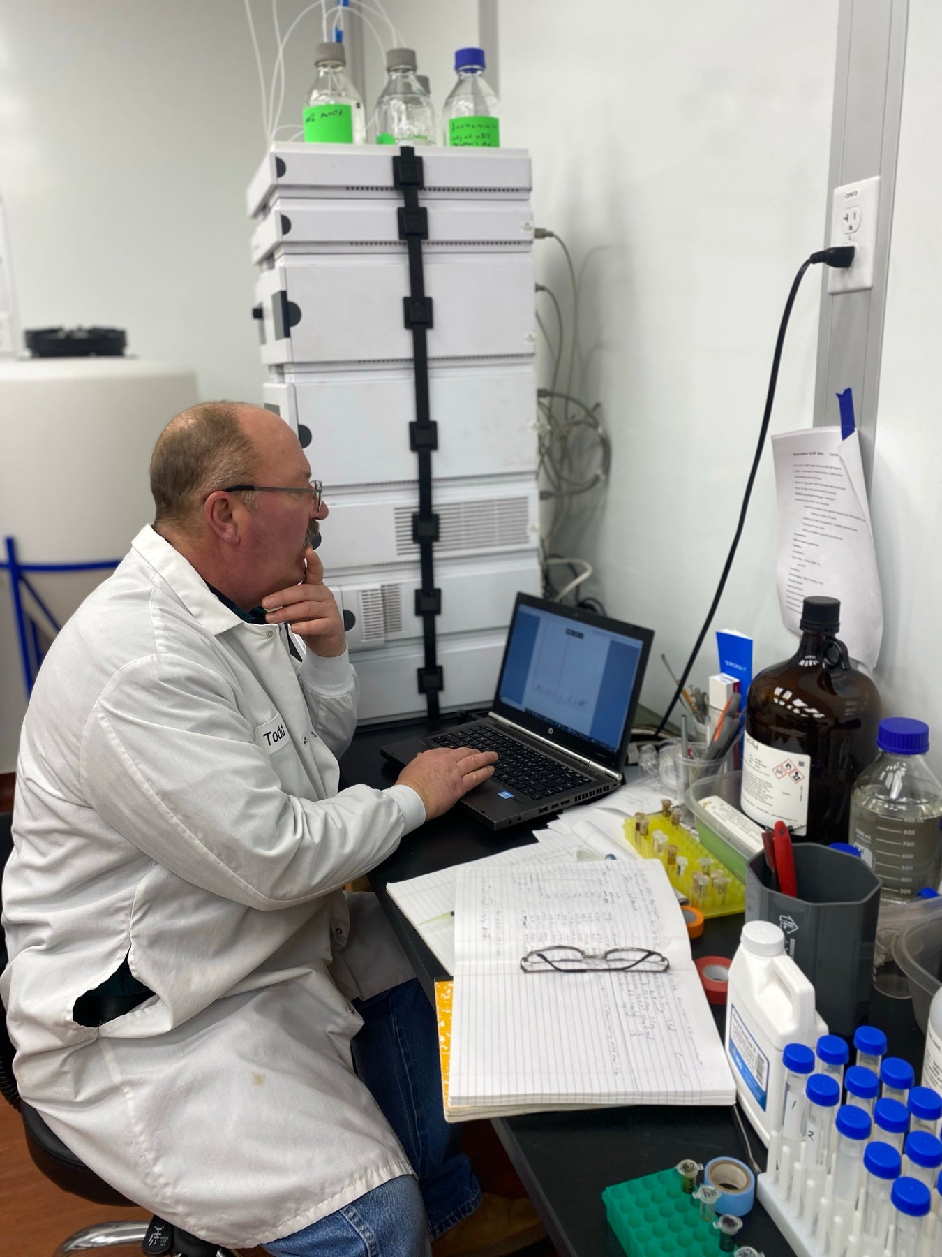 Chemist recording quality-control results at a lab bench