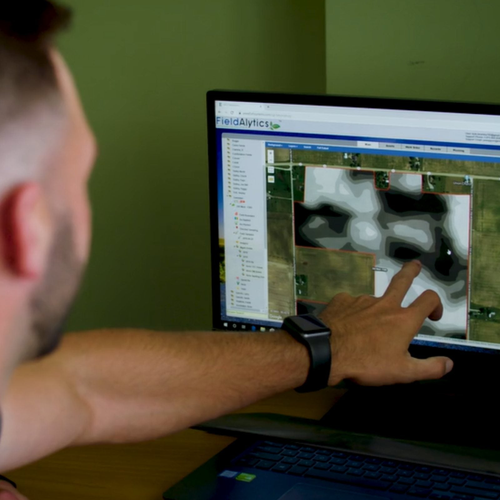 Farmer reviewing field soil data on a computer